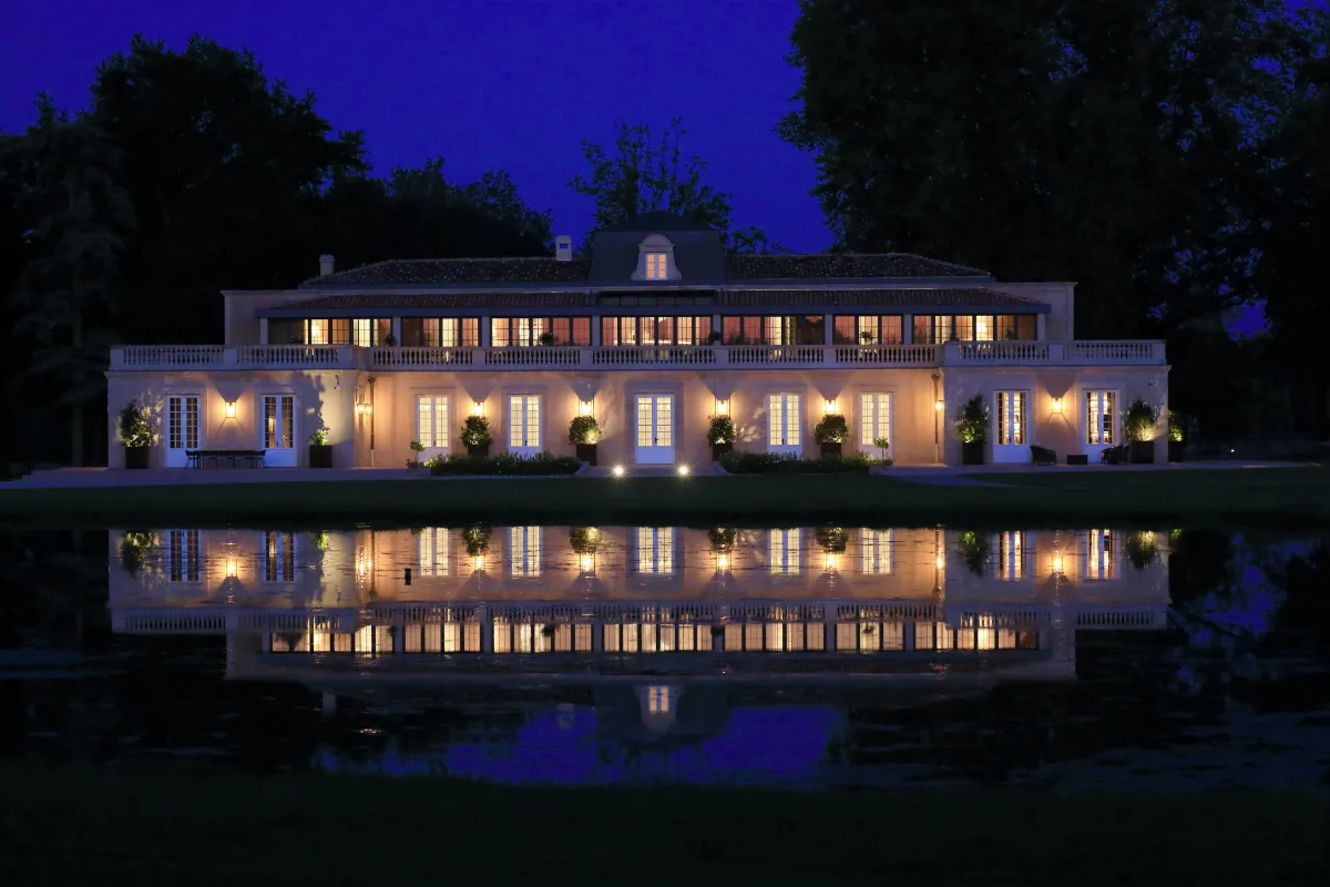 Chateau Dauzac lit at dusk and reflected in the water, Margaux