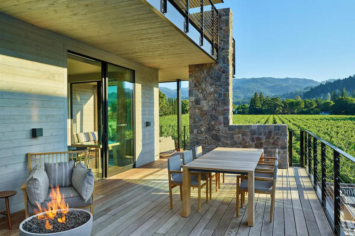 Stone terrace with a fire pit at Alila Napa Valley looking across vineyard rows to the hills