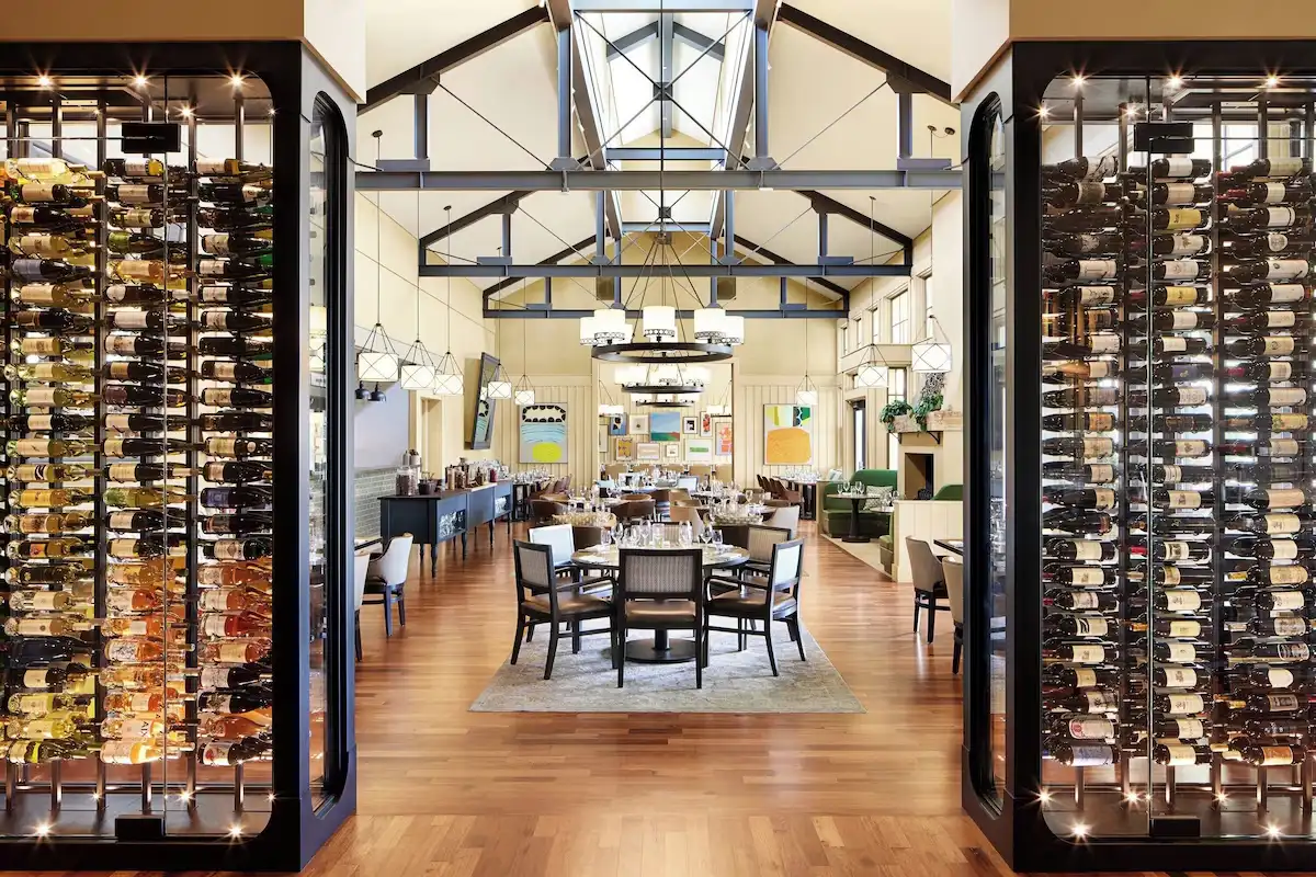 Dining room with floor-to-ceiling wine racks under a vaulted timber ceiling at Carneros Resort and Spa