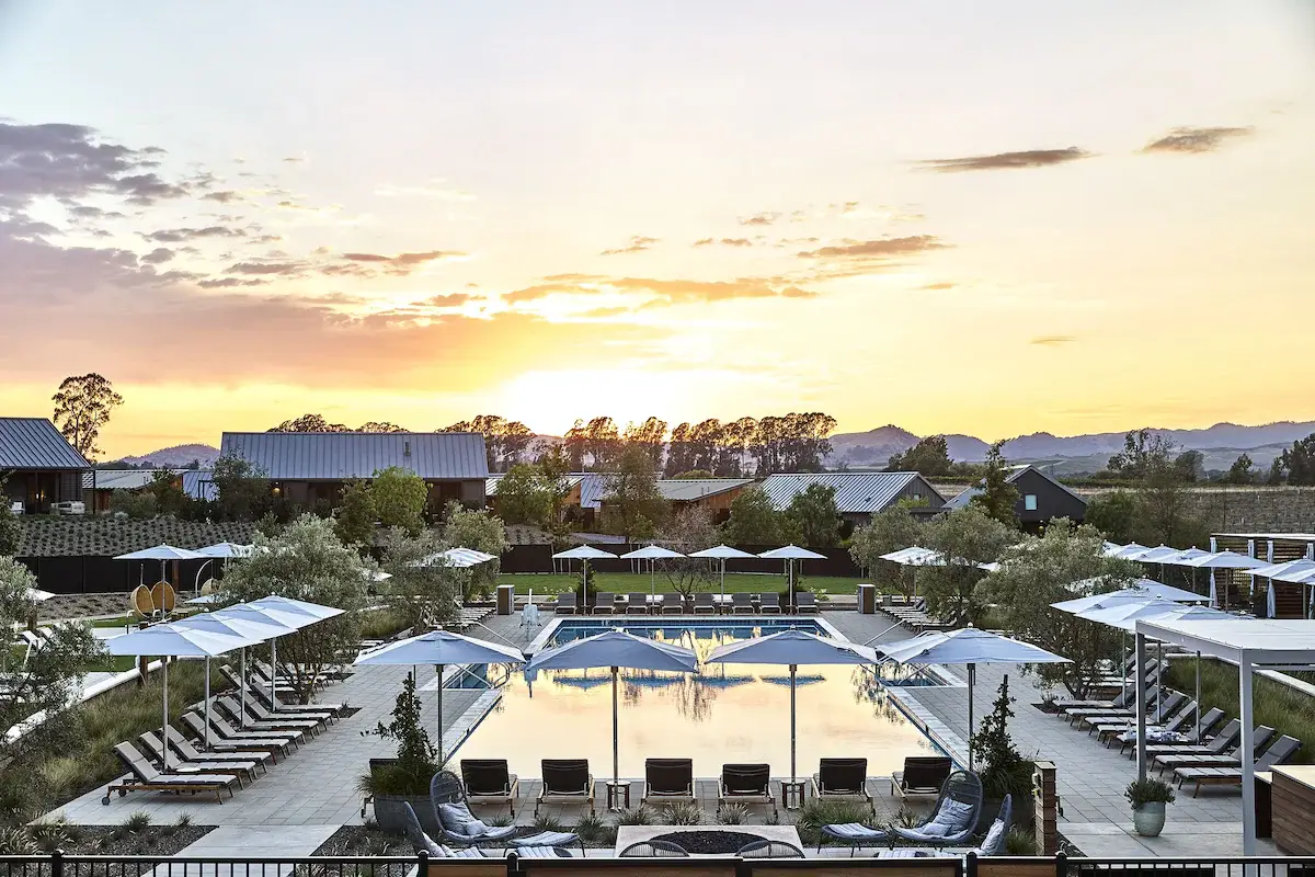 Aerial view at sunset of the pool and cottages at Stanly Ranch in Carneros, one of the Napa Valley wine resorts in this guide, with vineyard hills behind