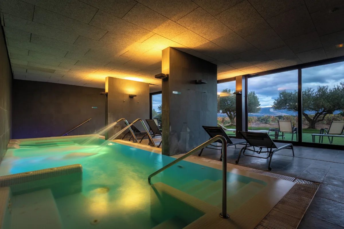 Indoor pool with glass walls onto the vines at Finca de Los Arandinos, one of the bodegas with rooms in Rioja
