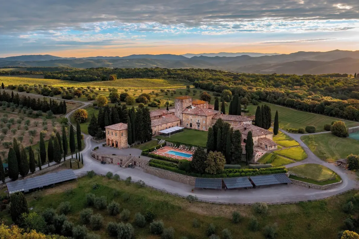 Aerial view of the Borgo Scopeto hamlet and its pool among woods and farmland at Vagliagli