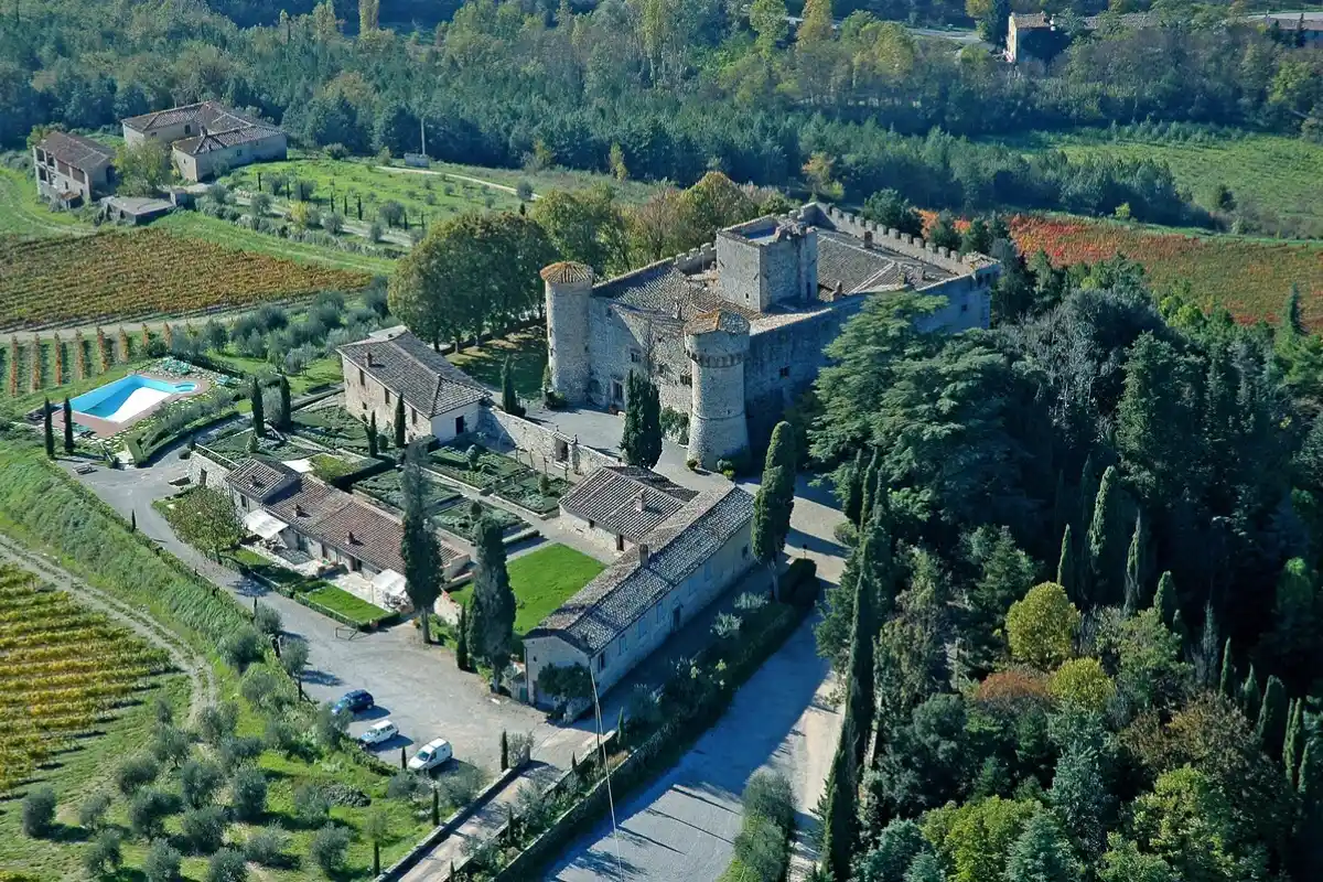 Aerial view of the castle, cypresses and pool at Castello di Meleto in Gaiole, one of the estates to consider for where to stay in Chianti
