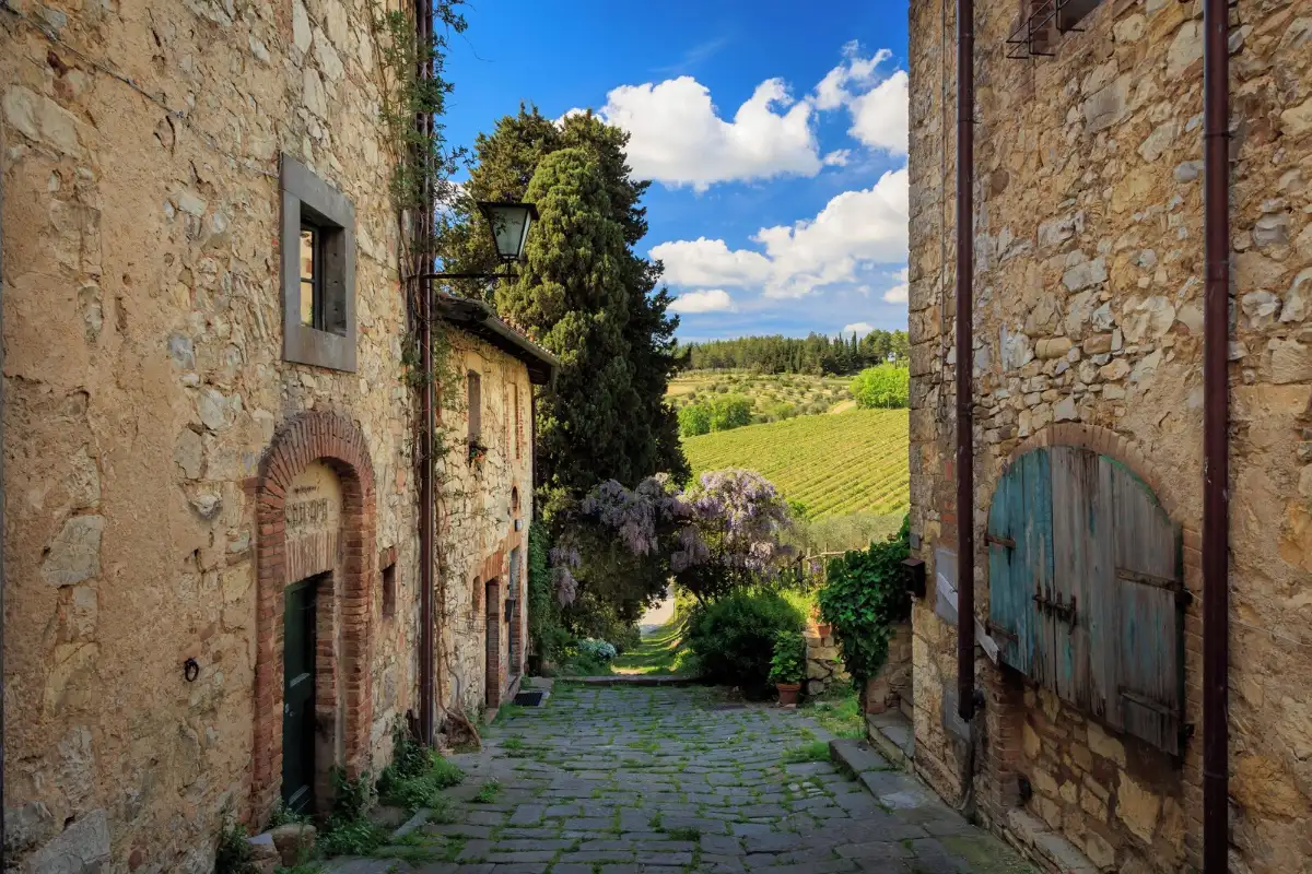 Old stone archway in the Fonterutoli hamlet opening onto green Chianti hills, Castellina in Chianti