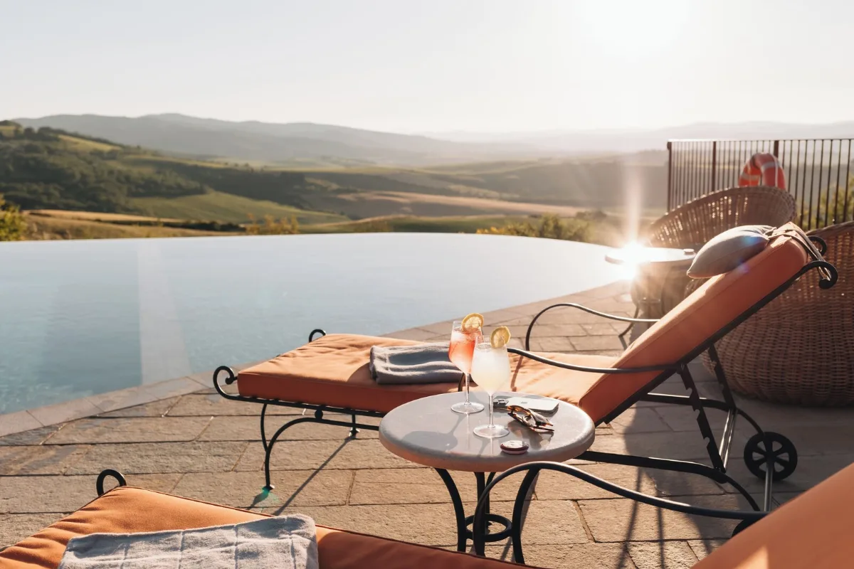 Infinity pool and sun lounger looking out over the hills from the terrace at Capanna Suites, north of Montalcino
