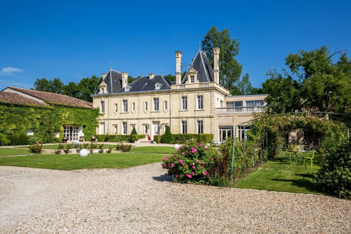The 17th-century façade of Château Meyre at Avensan, with its gravel drive, climbing roses and ivy-covered wing