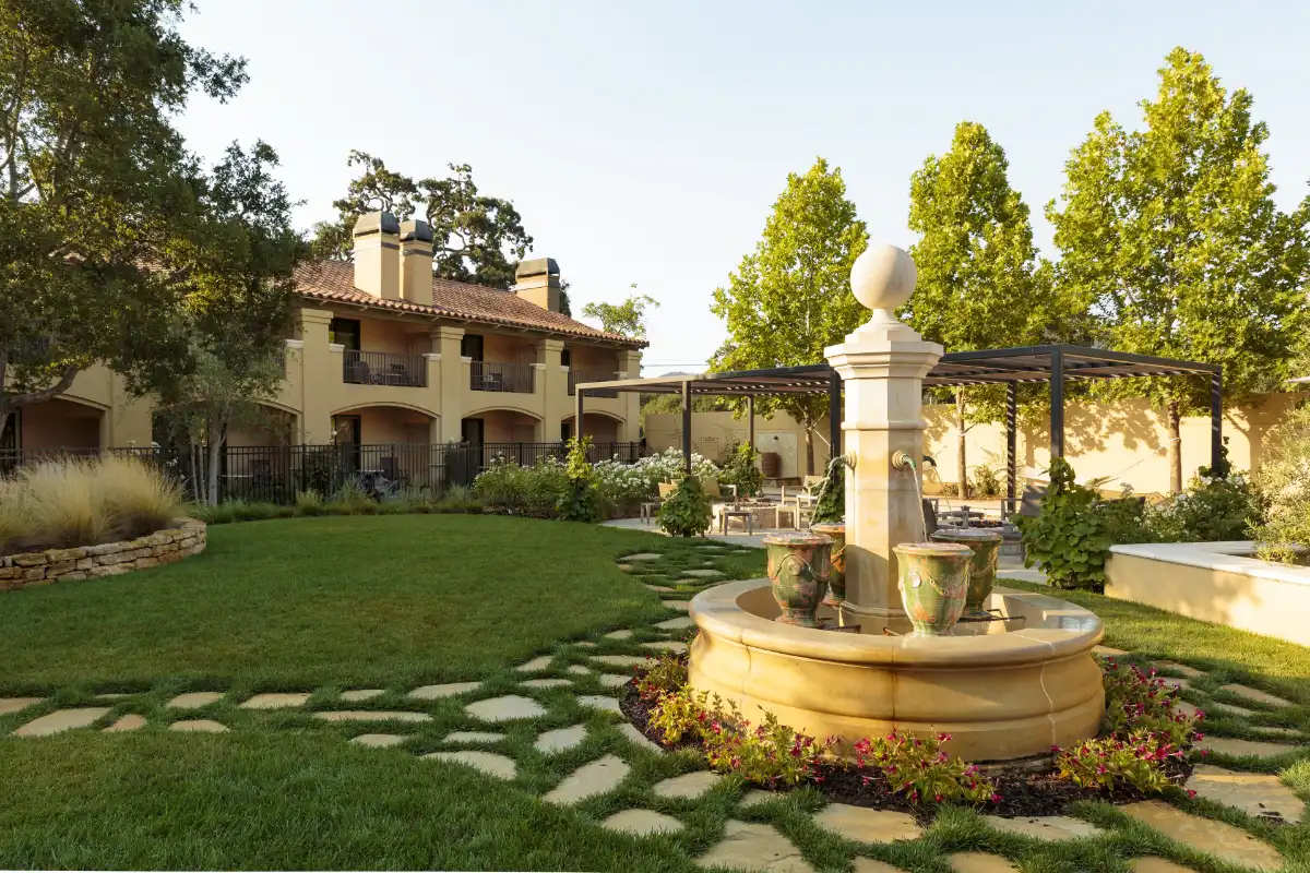 Lawn, stone pillar and pergola in front of the tile-roofed wings of Napa Valley Lodge in Yountville