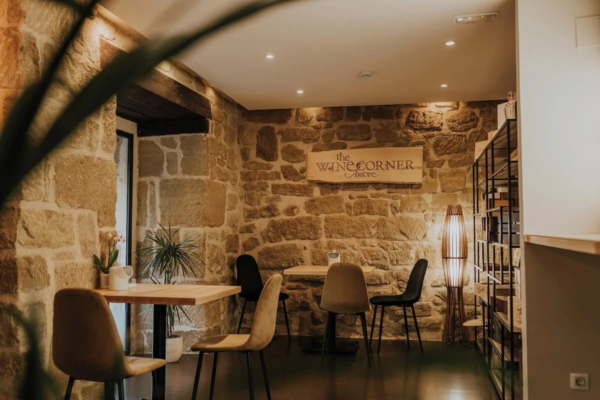 Stone-walled wine corner with small tables at Hotel Arrope in Haro