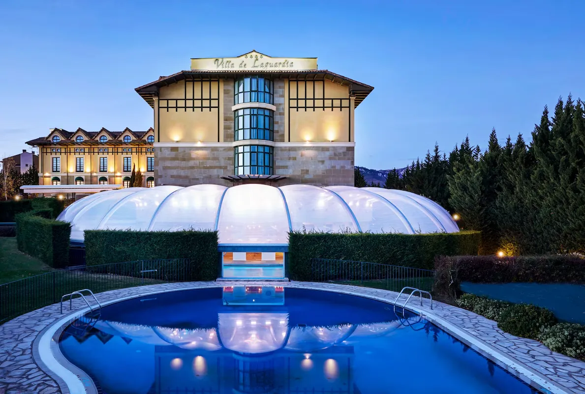 The floodlit domed pool in front of Silken Villa de Laguardia at dusk