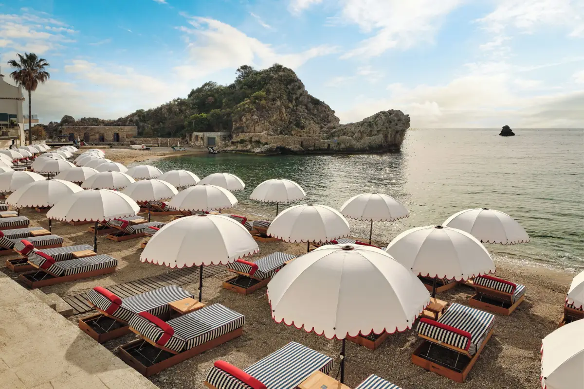 White parasols on the beach of Mazzarò Sea Palace, facing the rocky headland of the bay