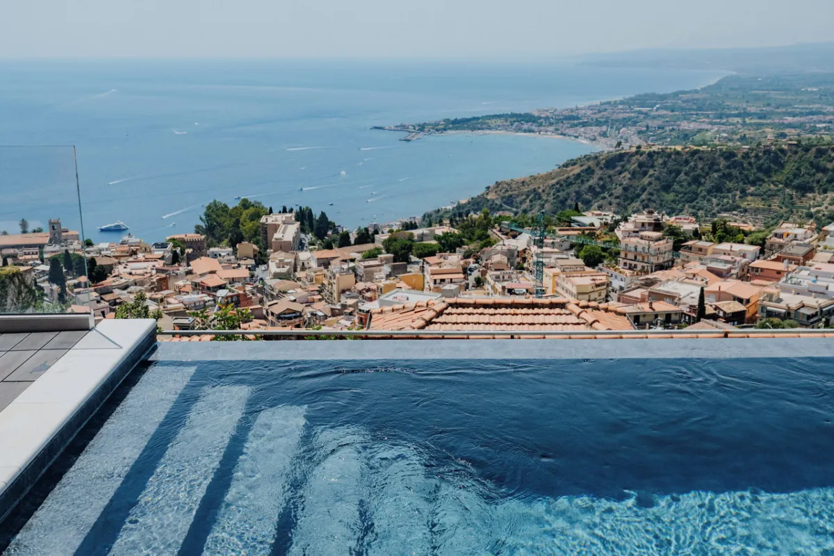Infinity pool at Hotel Villa Ducale looking over the rooftops of Taormina and the coast