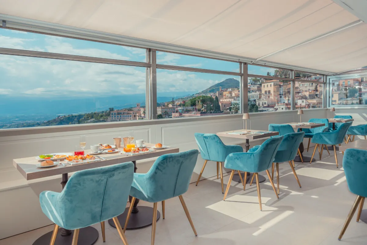 Breakfast room with panoramic windows over the coast at Hotel Villa Paradiso in Taormina