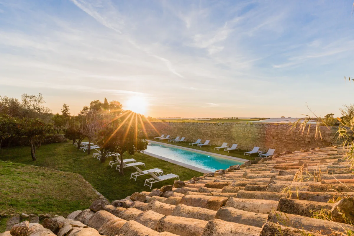 The pool of Baglio Occhipinti at sunset, seen over the farmhouse roof tiles near Vittoria
