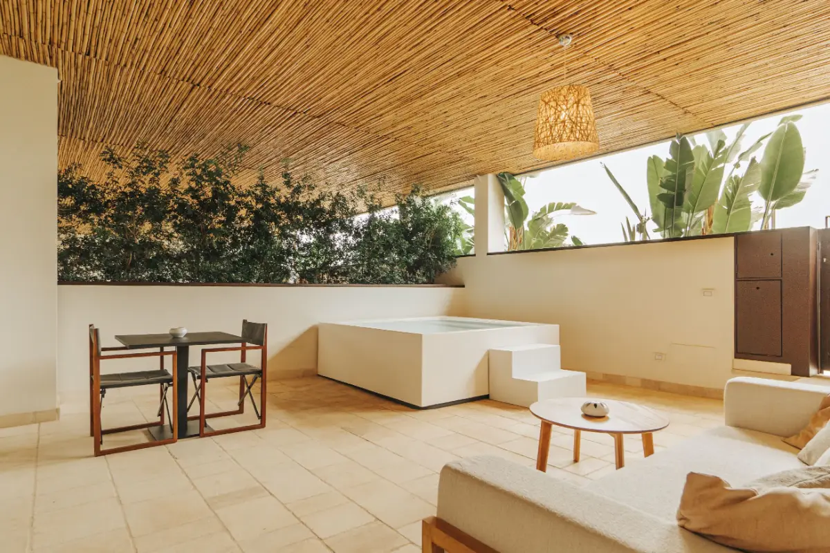 Shaded terrace with a reed canopy and lounge seating at Masseria Corsano