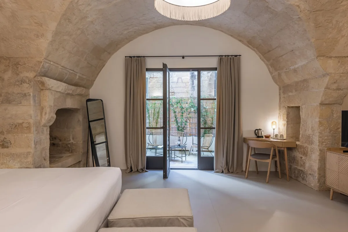 Room at Arco Vecchio Urban Suite in Lecce with a stone vault, a stone fireplace and French doors