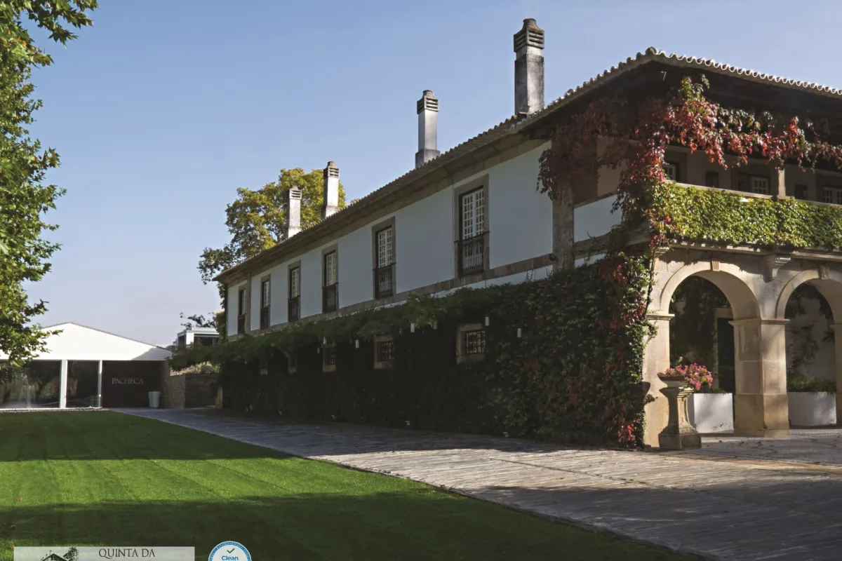 Whitewashed manor house of Quinta da Pacheca with stone arches and climbing vines
