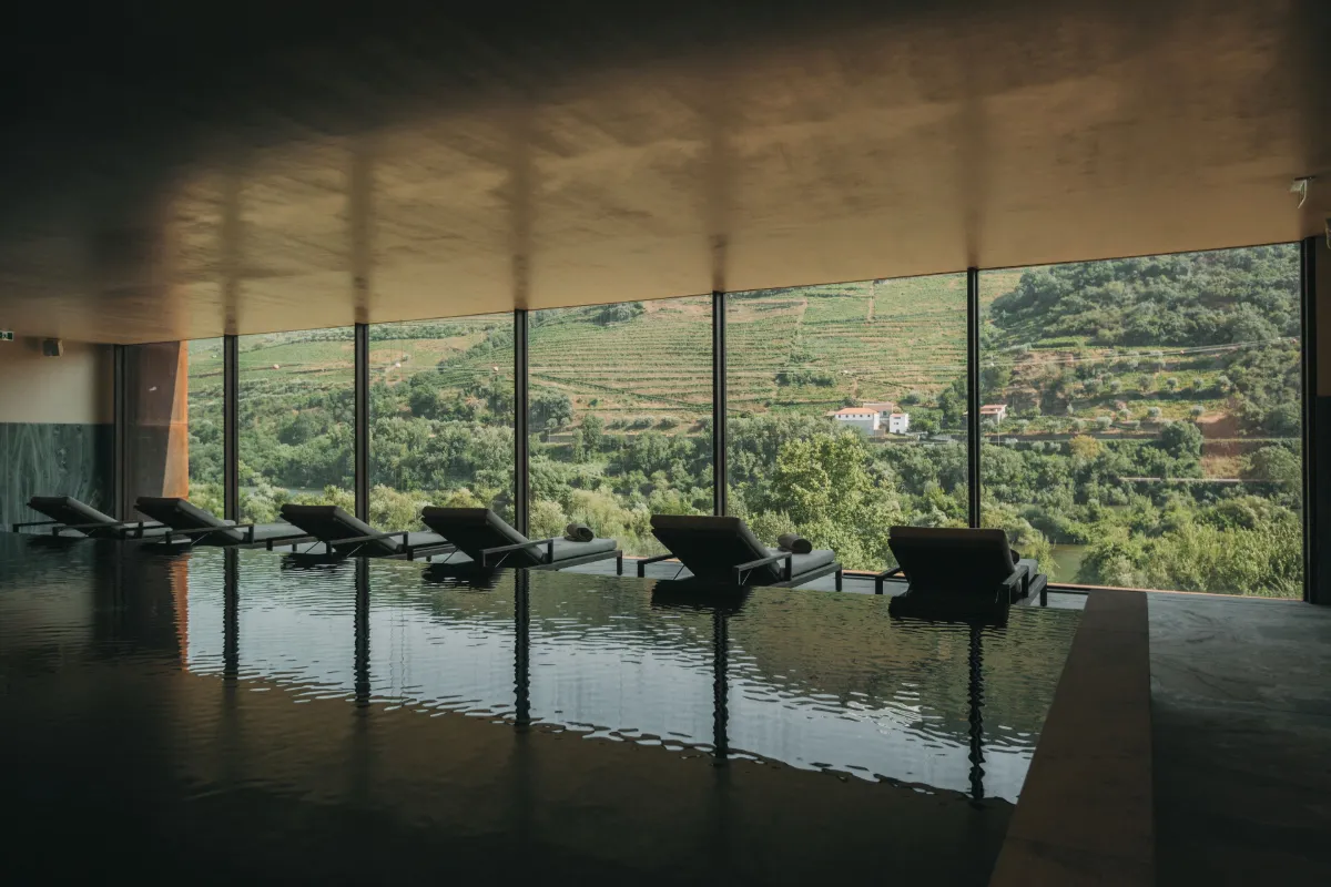 Loungers behind floor-to-ceiling windows overlooking terraced vineyards at Torel Quinta da Vacaria
