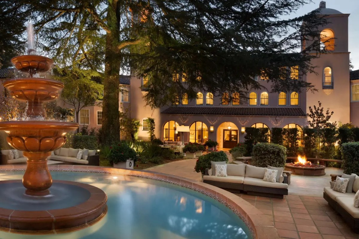 Fountain and pool in front of the mission-style building of Fairmont Sonoma Mission Inn & Spa at dusk