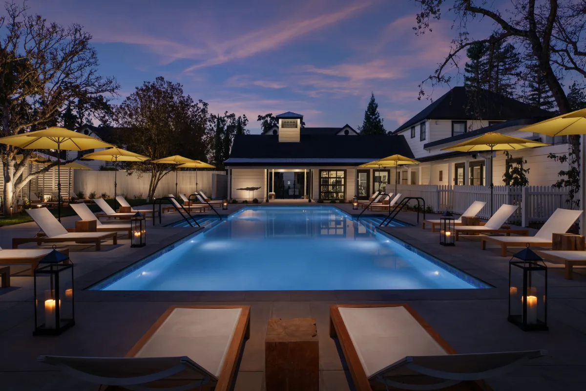 Lit pool with loungers and umbrellas at MacArthur Place Hotel & Spa in Sonoma at dusk