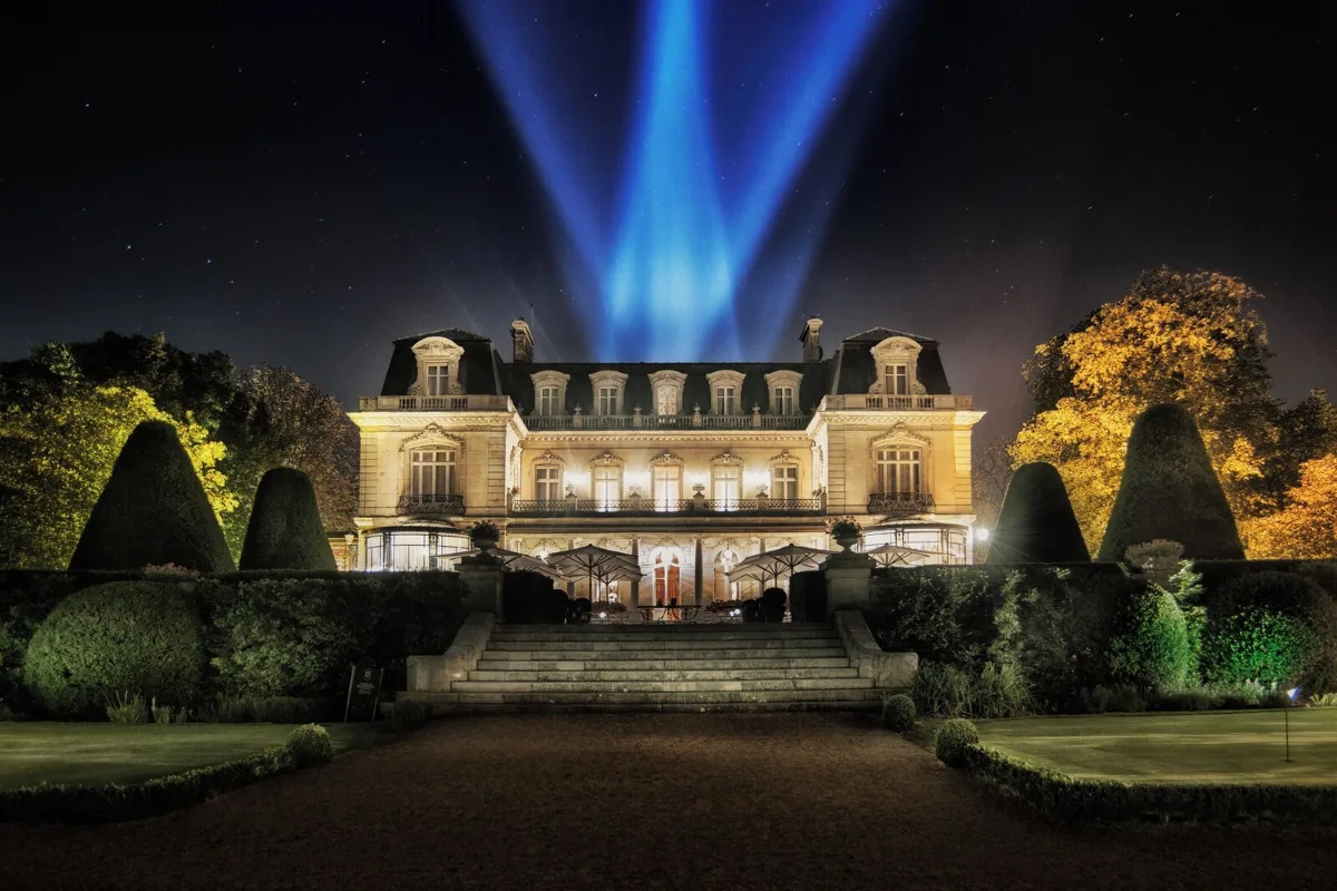 Domaine Les Crayères in Reims at night, the château lit up behind clipped topiary