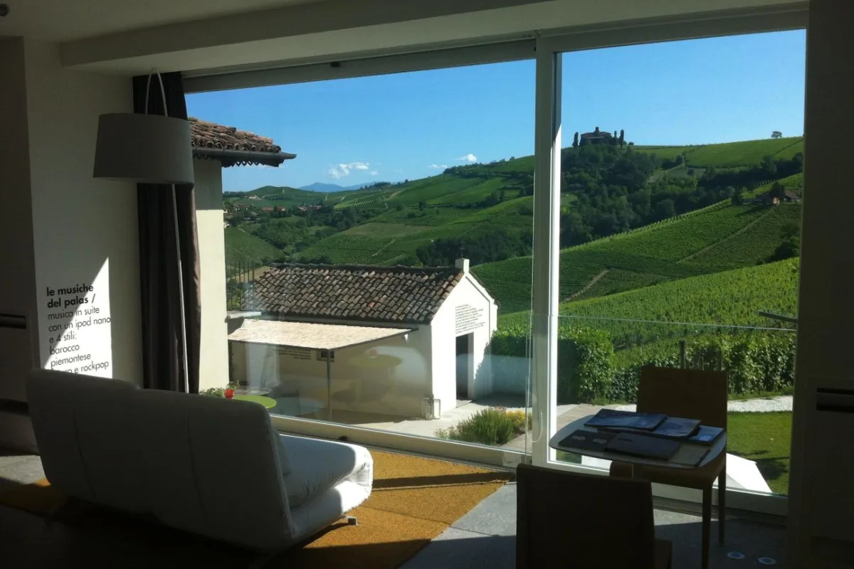 One of the Barolo hotels in this guide: a suite at Palas Cerequio with a glass wall opening onto vineyard hills